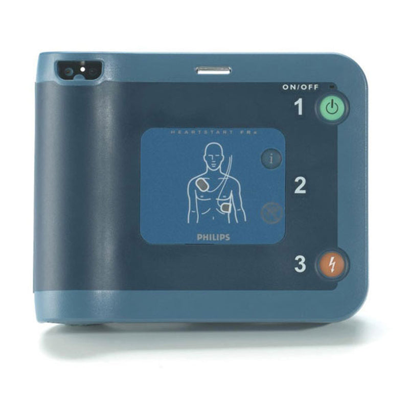 Philips HeartStart FRx Defibrillator with a blue casing, display showing a medical illustration and Philips branding, and control buttons.