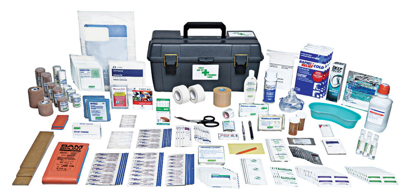 An extensive first aid kit with various medical supplies spread out next to a plastic utility box with a green cross on it.